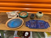 All six pottery pieces displayed on wooden surface
