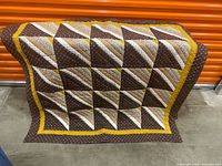 Full view of folded quilt showing pattern and colours