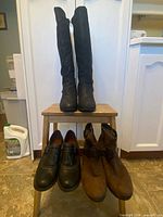 All three pairs of boots displayed on stool
