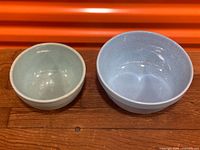 Two ceramic mixing bowls side by side, showing size and color difference