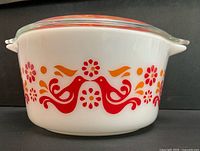 Side view of white Pyrex #473 casserole showing Friendship bird and floral motif