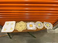 All eight doilies laid out on board
