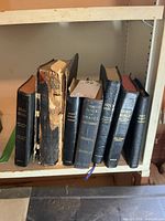 Seven religious books on shelf showing spines