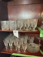 Shelved collection of pinwheel crystal glasses and plates
