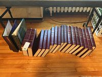 Full lot showing two photo albums and a row of Britannica yearbooks