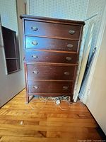 Front view of five-drawer dresser showing overall design and hardware