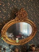 Full view of oval gold mirror on wall