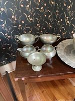 group of pewter creamers, sugar bowls, compote, trays on table