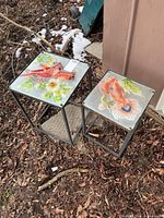 Both metal frame side tables outdoors showing decorative tops and size difference