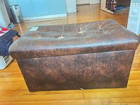 Front view of brown faux leather storage ottoman