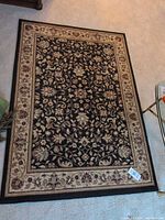 Full view of the Kathy Ireland floral area rug on carpeted floor