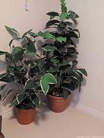 Two artificial potted plants side by side showing overall appearance and pots