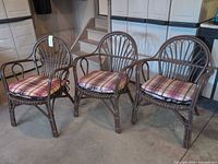 Front view of three painted bamboo armchairs with cushions