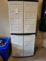 Front view of closed plastic cabinet showing two doors and exterior condition