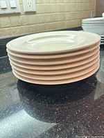 stack of seven cream plates side view