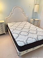 Bed assembled showing headboard, mattress, nightstands partially visible