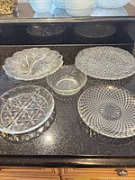 Five clear glass pieces displayed on countertop