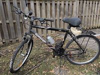 Left side view of bicycle showing frame graphics, water bottle, rear rack, saddle bag, horn