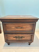 Front view showing full nightstand, drawers, brass pulls, rope trim