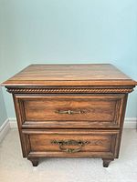 Front view of walnut nightstand showing two drawers and hardware