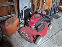 Full view of Toro mower, gas can, grass bag