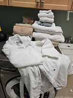 Stack of assorted towels and robe on washer