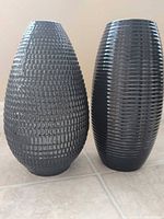 Front view of both black ceramic vases showing textures and shape