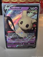 Front view of sleeved Mimikyu V card in top loader