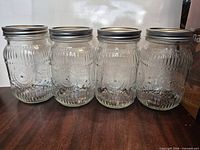 front view of four identical mason jars side by side on table