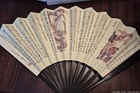 Fan fully opened showing calligraphy and landscape art