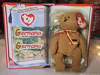 Front view of unopened book-style package showing Germania bear and title graphics