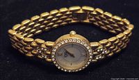 Front view showing gold-tone bracelet, crystal bezel, dial