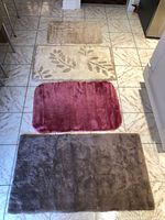 Four bath mats laid out largest to smallest