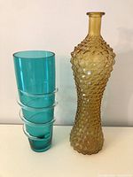 Amber Empoli glass bottle and teal swirl vase side by side