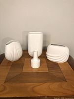 Group shot of four white porcelain vases