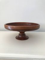 Side view of turned wood pedestal bowl on pedestal base
