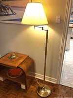 Full view of lamp lit with shade, base to finial