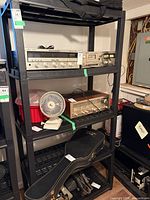 Full view of black plastic shelving with equipment on it