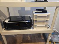 Canon printer, drawer organizer, stapler arranged on shelf