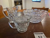 Three clear cut crystal pieces on table showing overall set