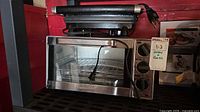 Front view of Hamilton Beach toaster oven with PC grill stacked above showing overall condition and cords