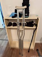 Overall view of crutches, cane, CAM boot, and braces on shelf