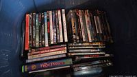 Blue tote with approximately forty DVD cases showing multiple visible titles