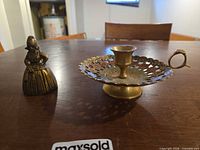 Figural bell and chamberstick front view on table