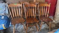 Front view of six matching brown wood spindle-back dining chairs