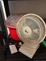 Front view of Super desktop fan beside popsicle maker showing size, colors and overall condition