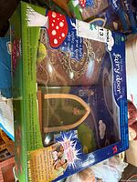 Front of boxed fairy door kit showing wooden door and included accessories