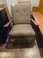Front view showing upholstery tears and wood arms