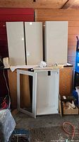 Three tall white gloss cabinet doors and an open base cabinet box