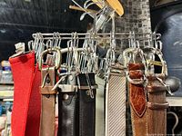 Rack showing belts and suspenders with buckles and clips visible